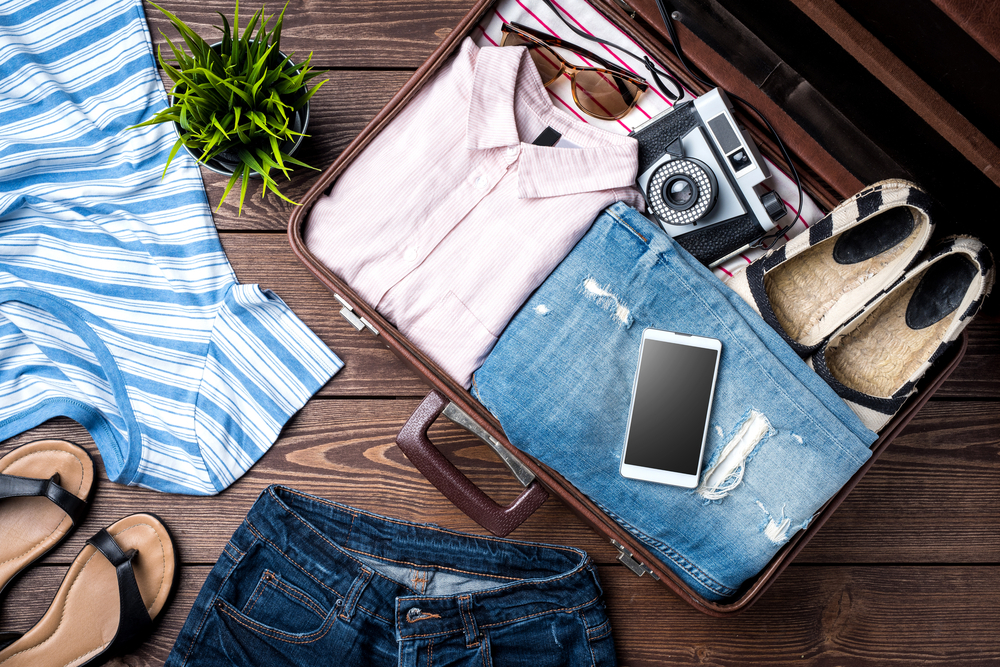 Open,Suitcase,With,Casual,Female,Clothes,On,Wooden,Table